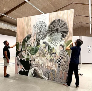 JOAO ALEXANDRINO et une autre personne tenant une oeuvre giganstesque